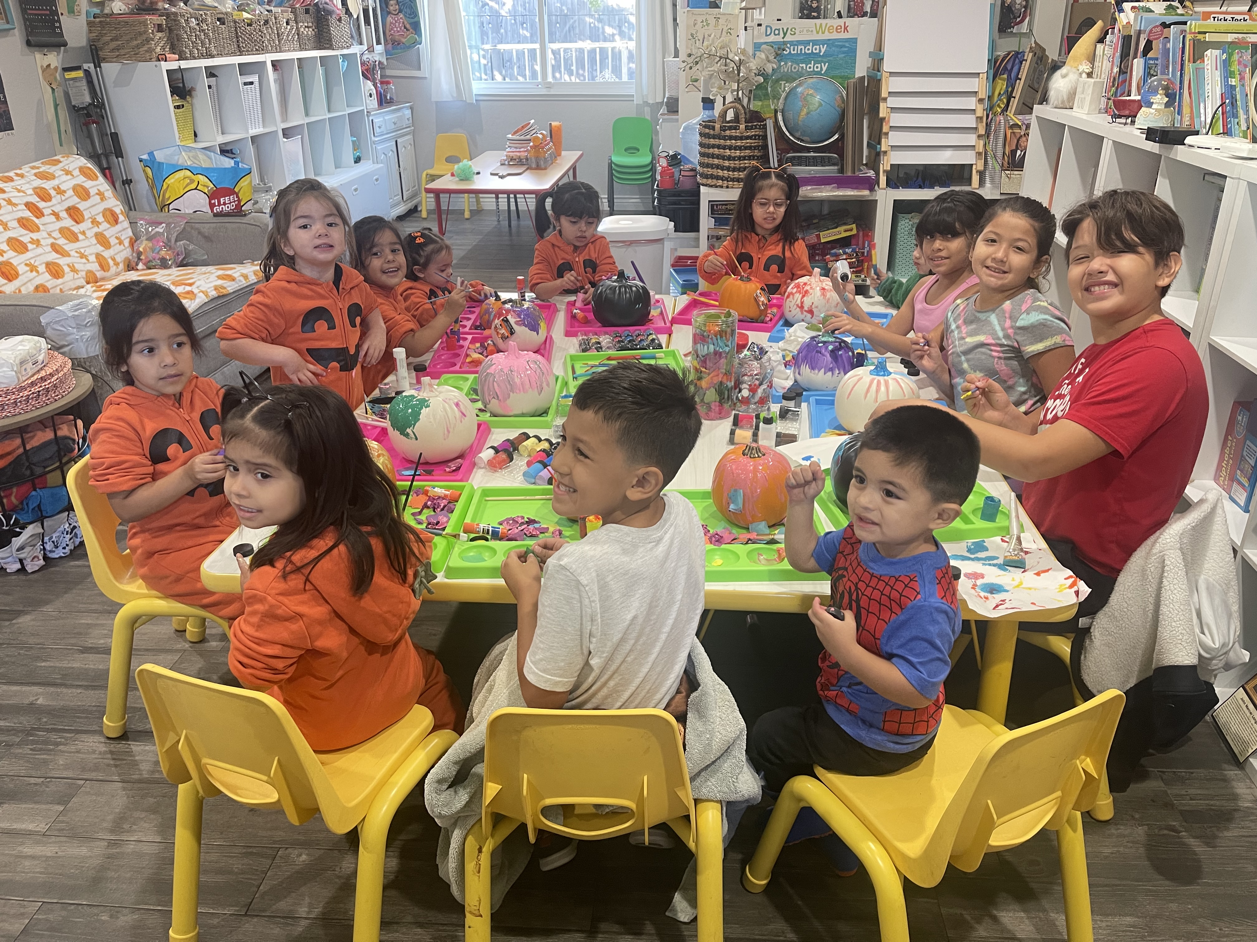 Children painting pumpkins together during a holiday activity